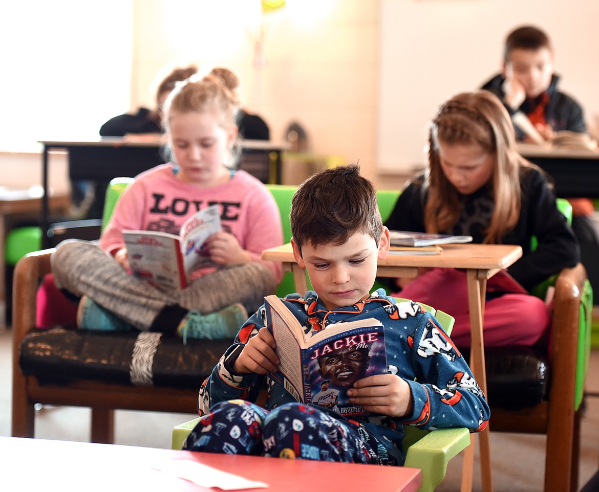 BRODY MORRISON, center, reads a book during Jennifer Watson&#146;s class on Thursday at Muldown Elementary in Whitefish. Morrison is wearing pajamas because the day was designated &#147;comfy&#148; day at school. (Brenda Ahearn/Daily Inter Lake)