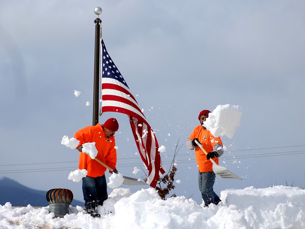 Crew members from the Idaho Department of Corrections shovel snow off of the roof of the Boundary County Restorium on Friday. 

(Photo by 
STAR SILVA)