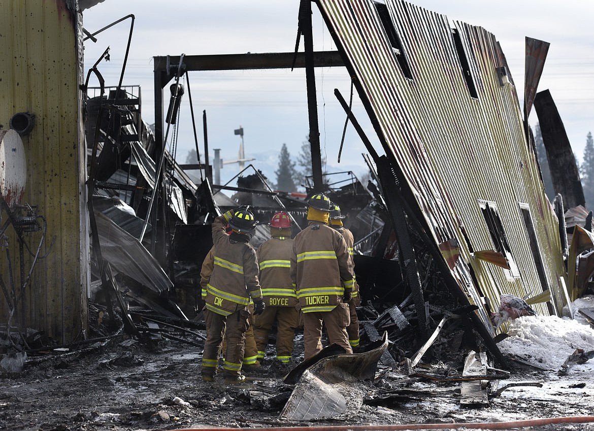 Firefighters survey the damage after the fire at Reddig Equipment and Repair on U.S. 2 in Evergreen on Wednesday. (Aaric Bryan/Daily Inter Lake)