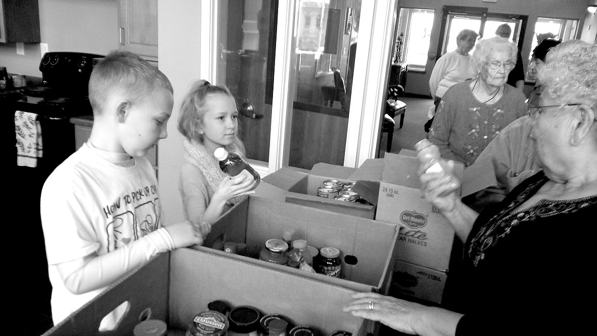 Dennis L. Clay photo 
J.T. Vieira, 9, left, and Selah Loomis, 9, volunteer at Pioneer Village Senior Apartments to hand out food from the Moses Lake Food Bank. This was J.T.&#146;s second time to volunteer at PV and Selah&#146;s first.