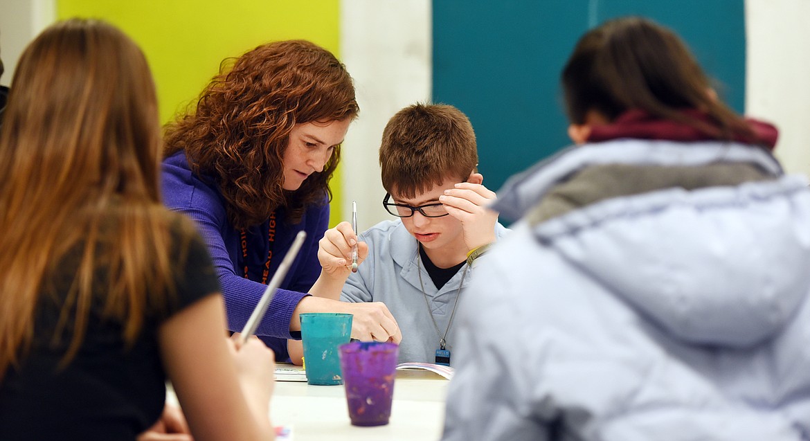 Art teacher Cris Robertson helps Nathaniel Mycroft with his Valentine&#146;s Day card as he and others from People First of Kalispell, a program sponsored by Special Friends Advocacy, make cards with Flathead High School Art Club students on Monday.