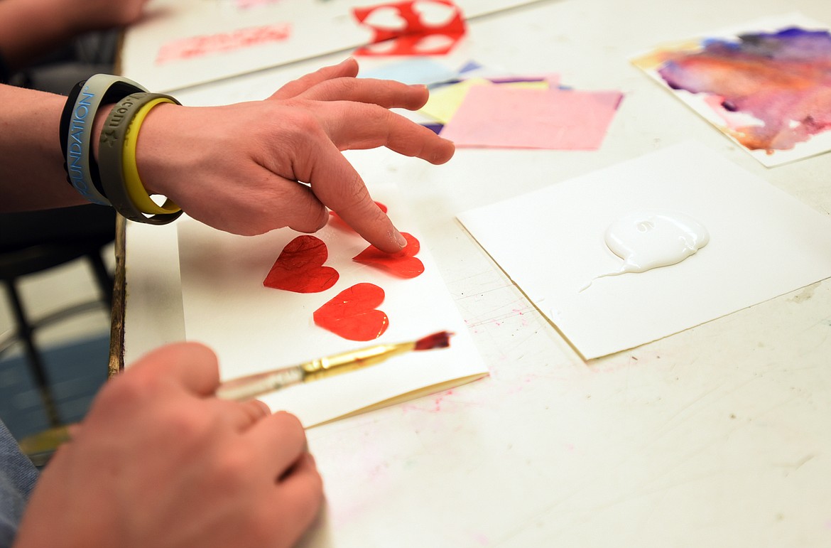 Nathaniel Mycroft glues decorative paper hearts to a Valentine&#146;s Day card he made on Monday afternoon.