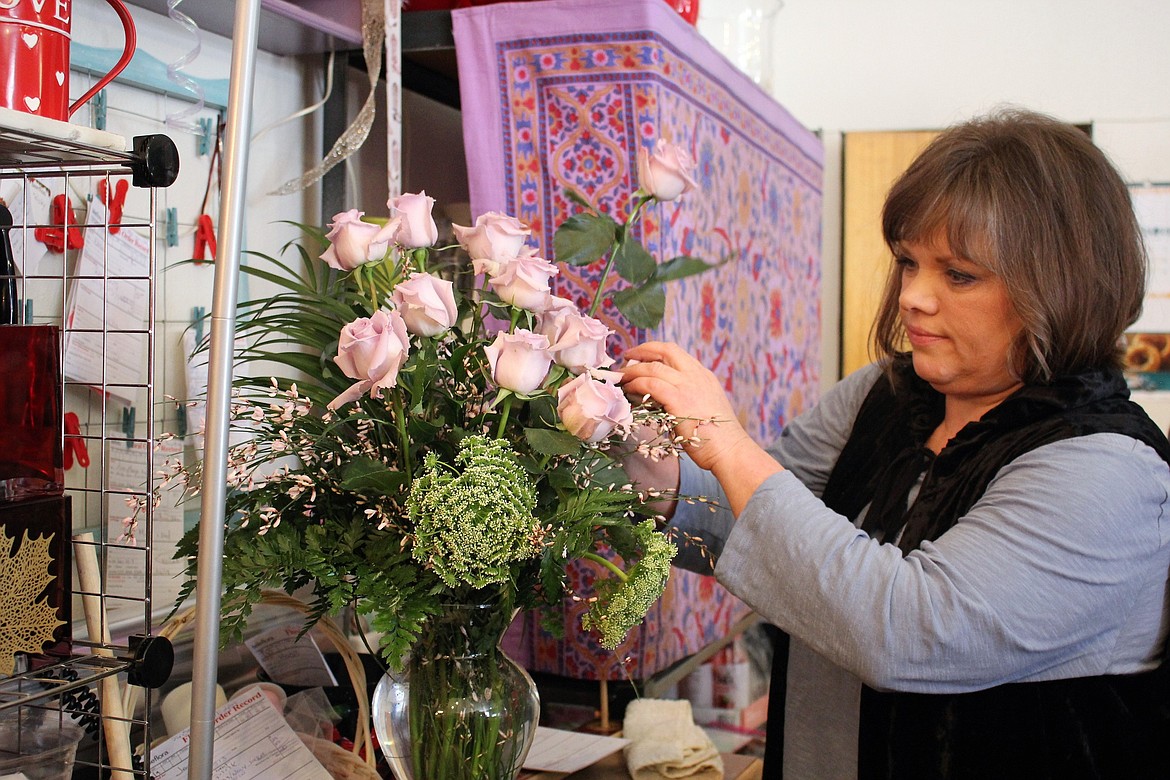 Sue Gross, an employee at Jackie&#146;s Flower Shop, creates an arrangement with purple roses. The shop will sell about 400 roses for Valentine&#146;s Day. (Kathleen Woodford/Mineral Independent).