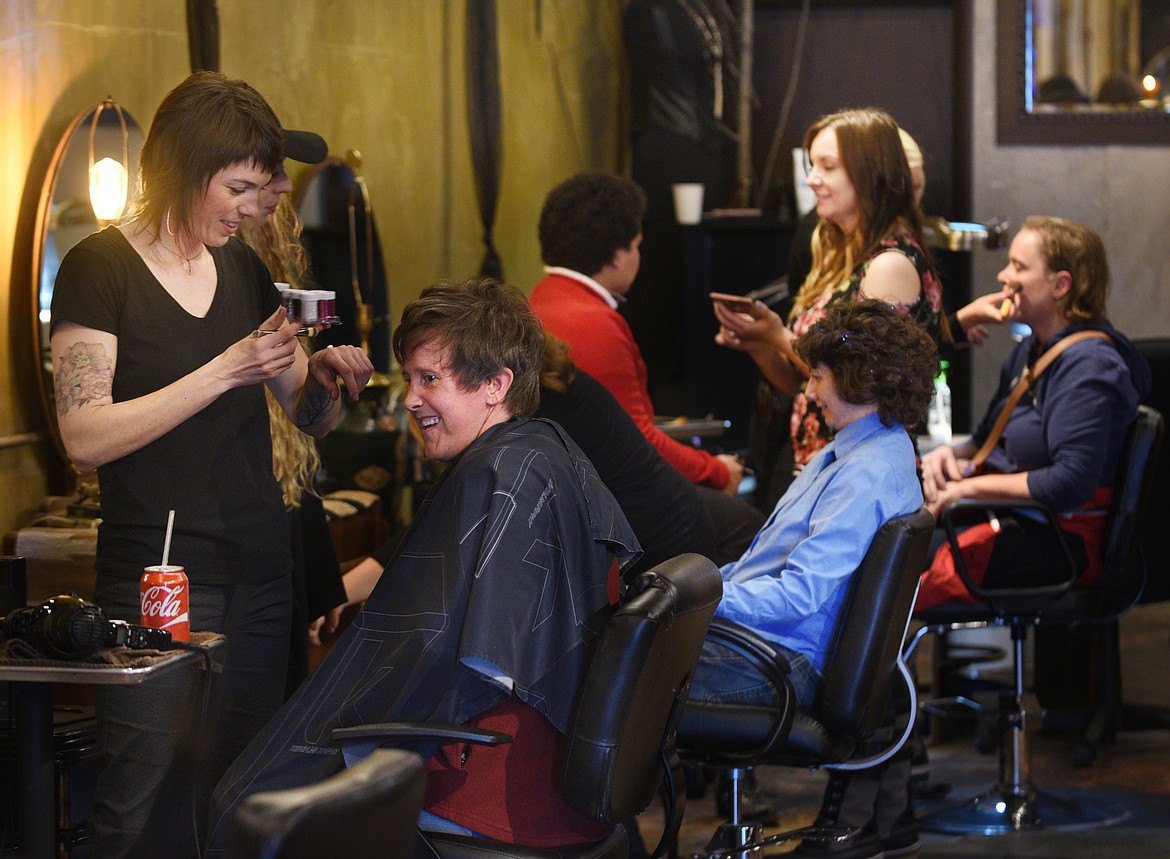 Jamey Herron smiles as she gets sparkles in her hair by stylist Jen Mulkey at the Soucie Soucie Salon and Medispa for the Night to Shine dance on Friday. (Aaric Bryan/Daily Inter Lake)