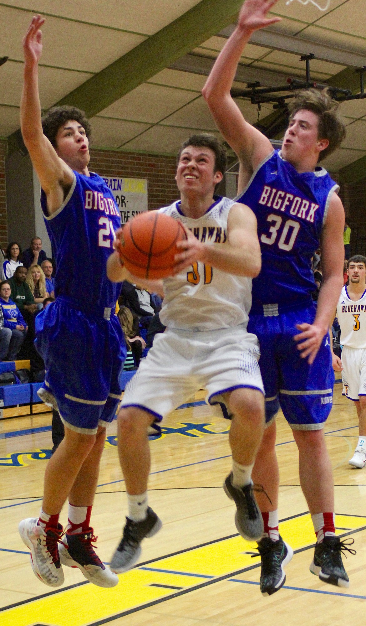 THOMPSON FALLS Bluehawk Nathan Thibeault (31) is crowded at the basket by Bigfork Vikings Chase Chappuis (21) and Logan Gilliard (30).