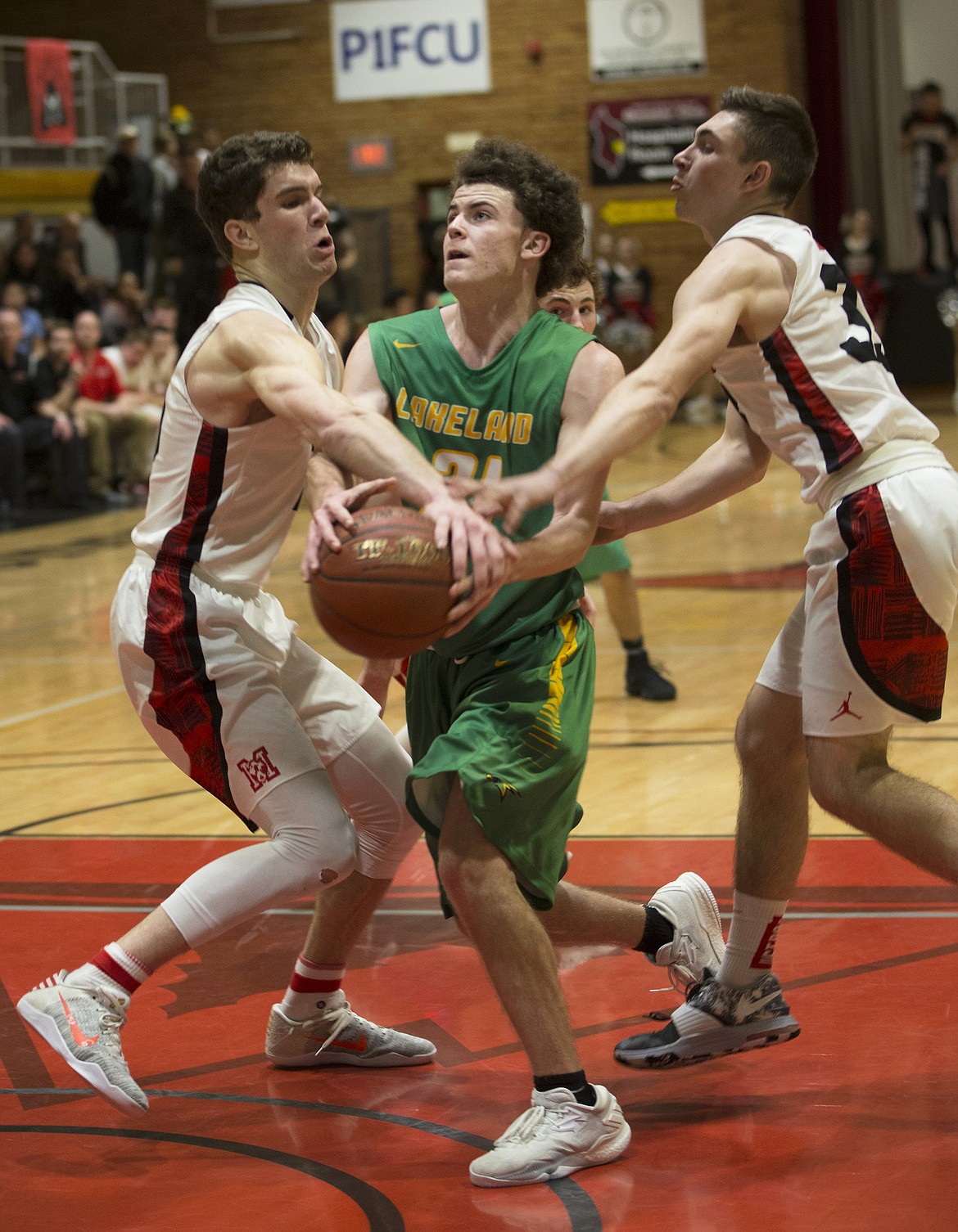 Dylan Knight, center, of Lakeland, is defended by Moscow players 
Hunter Pickard, left, and Jake Knott in the last minutes of their 4A Region 1 championship game at North Idaho College on Thursday night. Lakeland lost to Moscow, 45-44.
LISA JAMES/Press