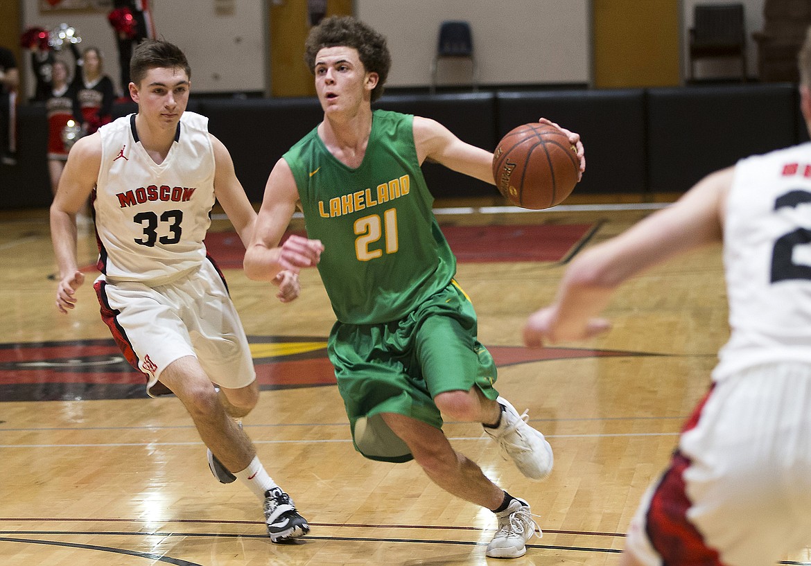 LISA JAMES/PressDylan Knight drives down the court with Jake Knott of  Moscow close at his heels during their 4A Region 1 championship game at NIC on Thursday night. Lakeland lost to Moscow, 44-45.