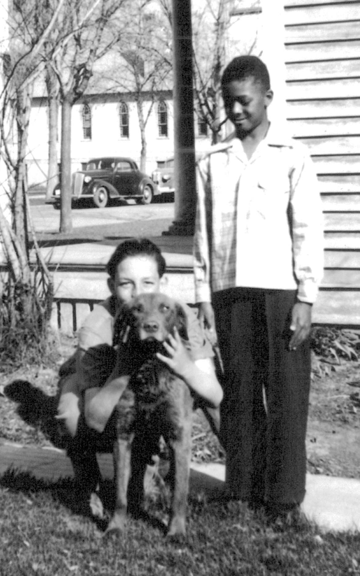 Sylvester Douglas Thompson, who went by Douglas, poses with a neighborhood friend and his dog when he was about 10 years old.