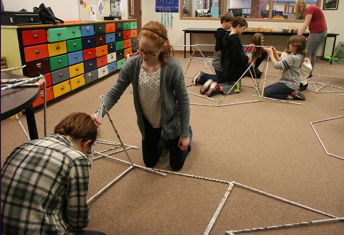 WHITEFISH MIDDLE School sixth-graders Ava Metcalfe and Cecilia Bookmiller, right, build a dome out of newspaper and tape Friday in the library makerspace. (Hilary Matheson/Daily Inter Lake)