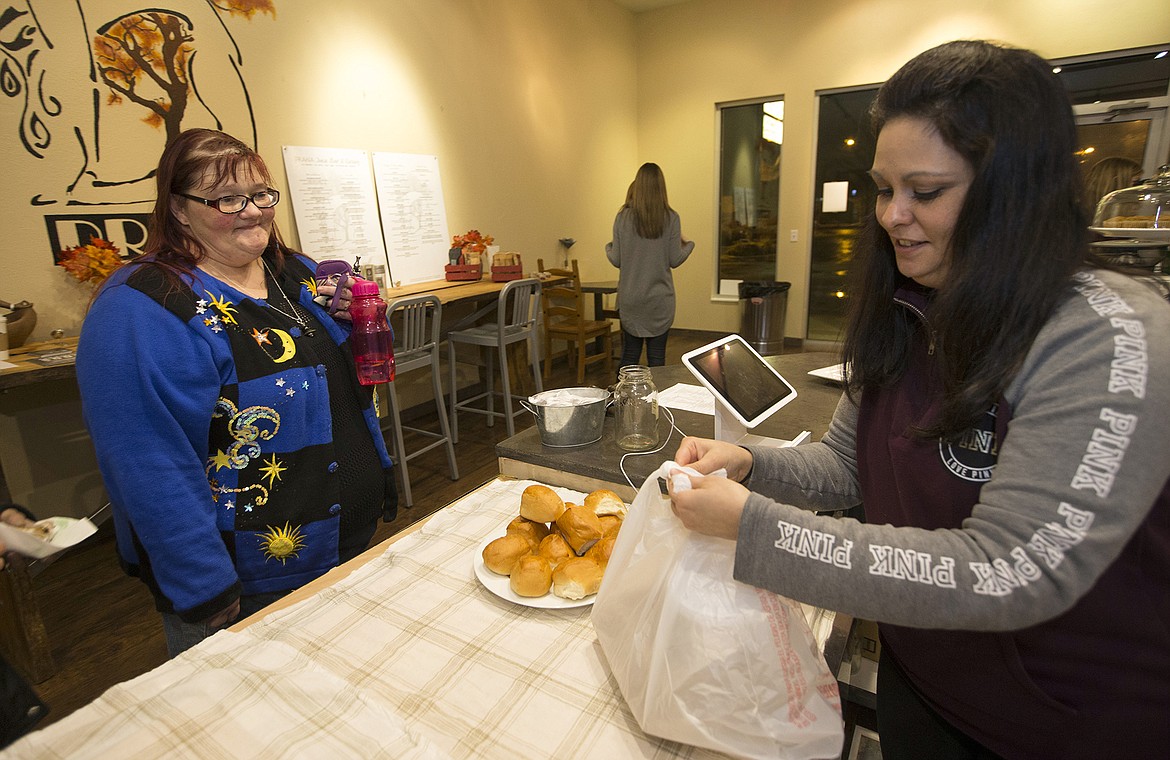LISA JAMES/PressPrana Juice Bar and Eatery owner Jennifer Swope, right, bags up homemade soup for client Brenda Heigel to take away with her last Tuesday evening. Prana has recently partnered with Life Center CDA Church to provide free healthy soup every Tuesday evening in their cozy cafe on Sunset Avenue.