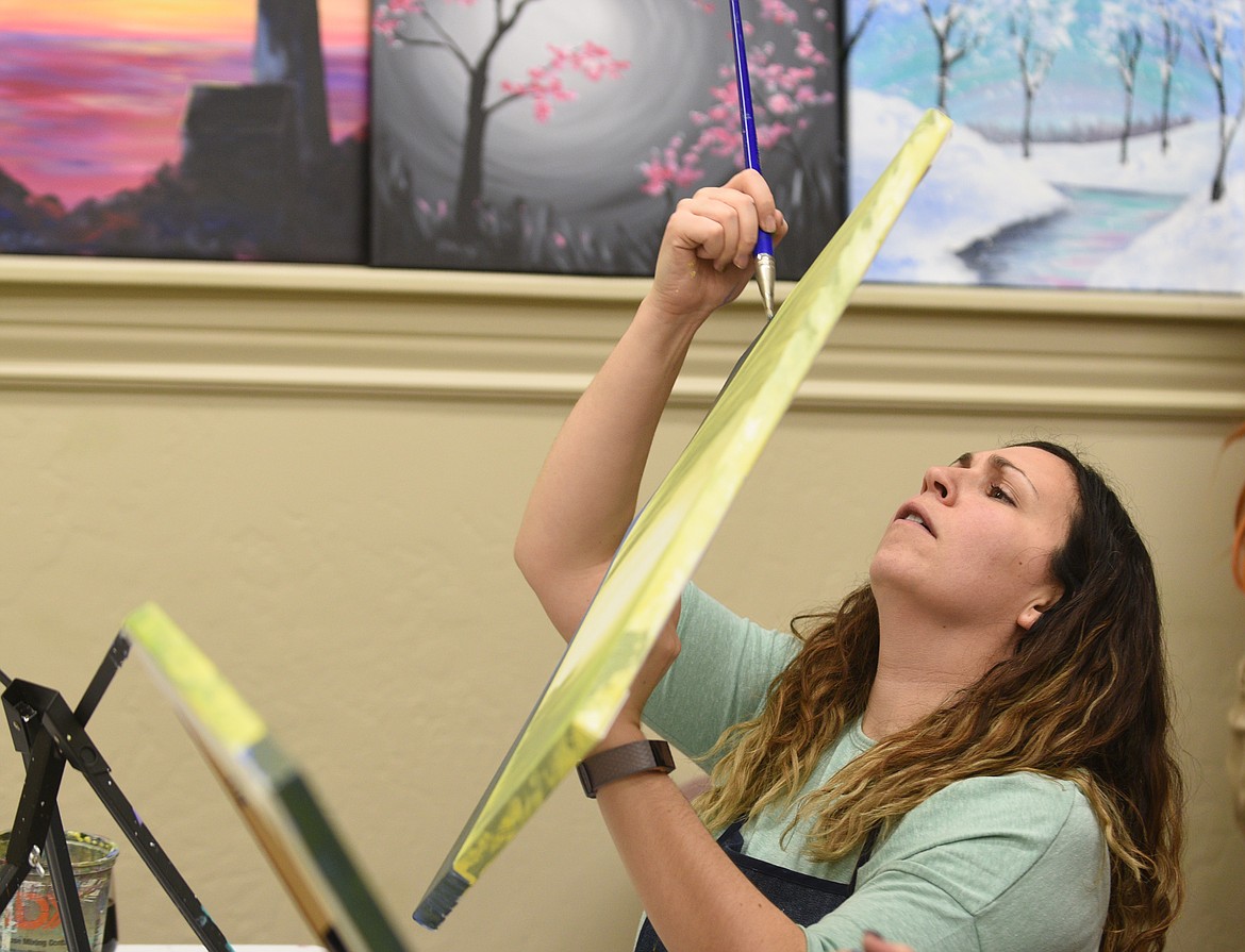 Aryn Kientz paints the edges of her painting. (Aaric Bryan photos/Flathead Journal)