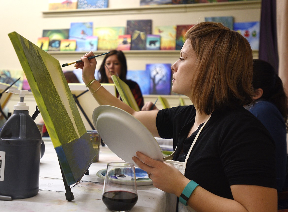 Cayla Johnson works on the trees in her painting at a recent Tipsy Brush painting party. (Aaric Bryan/Flathead Journal)