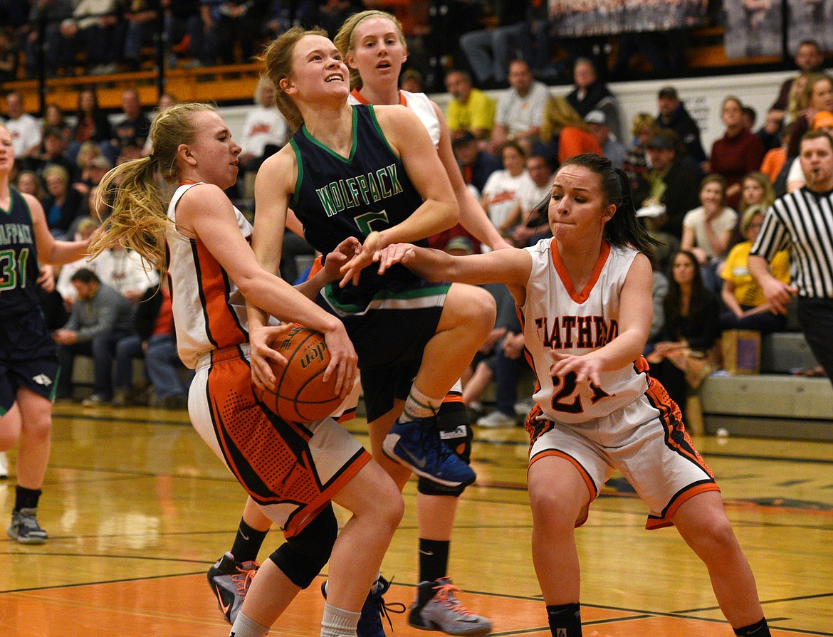 Glacier guard Cadie Williams is fouled as she is swarmed by Flathead defenders during the second half of the Bravettes' 39-34 victory. (Aaric Bryan/Daily Inter Lake)