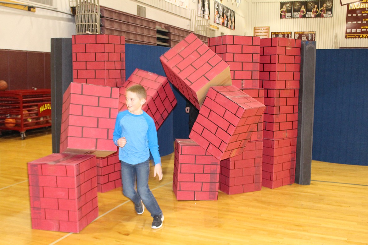 Cheryl Schweizer/Columbia Basin Herald
Boys went busting through a brick wall (made of cardboard boxes) to save their moms at Mother-Son night out Saturday.