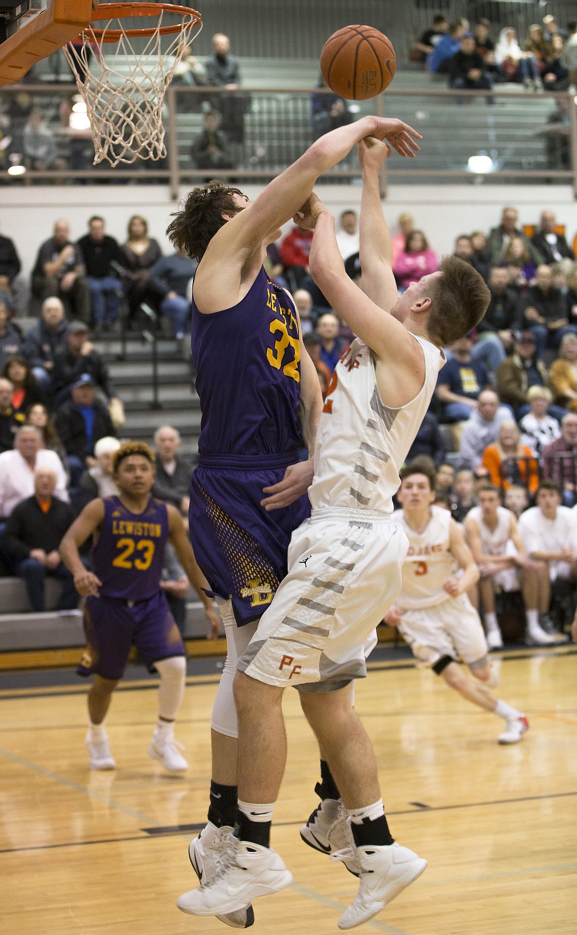 LISA JAMES/ PressDavid Bourgard of Post Falls is blocked by Trystan Bradley of Lewiston during their State 5A Region 1 championship game at Post Falls High School on Tuesday night. Post Falls lost to Lewiston, 48-51.