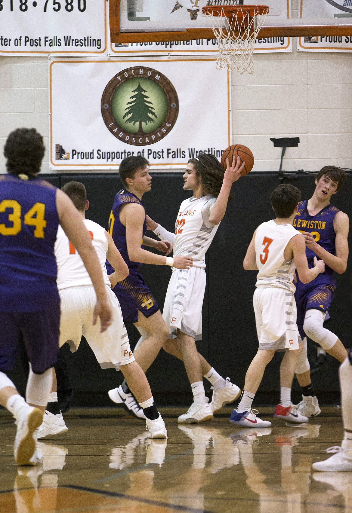 LISA JAMES/ PressCasey Walker, 11, gets ready to shoot as Colton Richardson, #34, Riley Way, #24, and Trystan Bradley, #32, of Lewiston block during their State 5A Region 1 championship game at Post Falls High School on Tuesday night. Post Falls lost to Lewiston, 48-51.