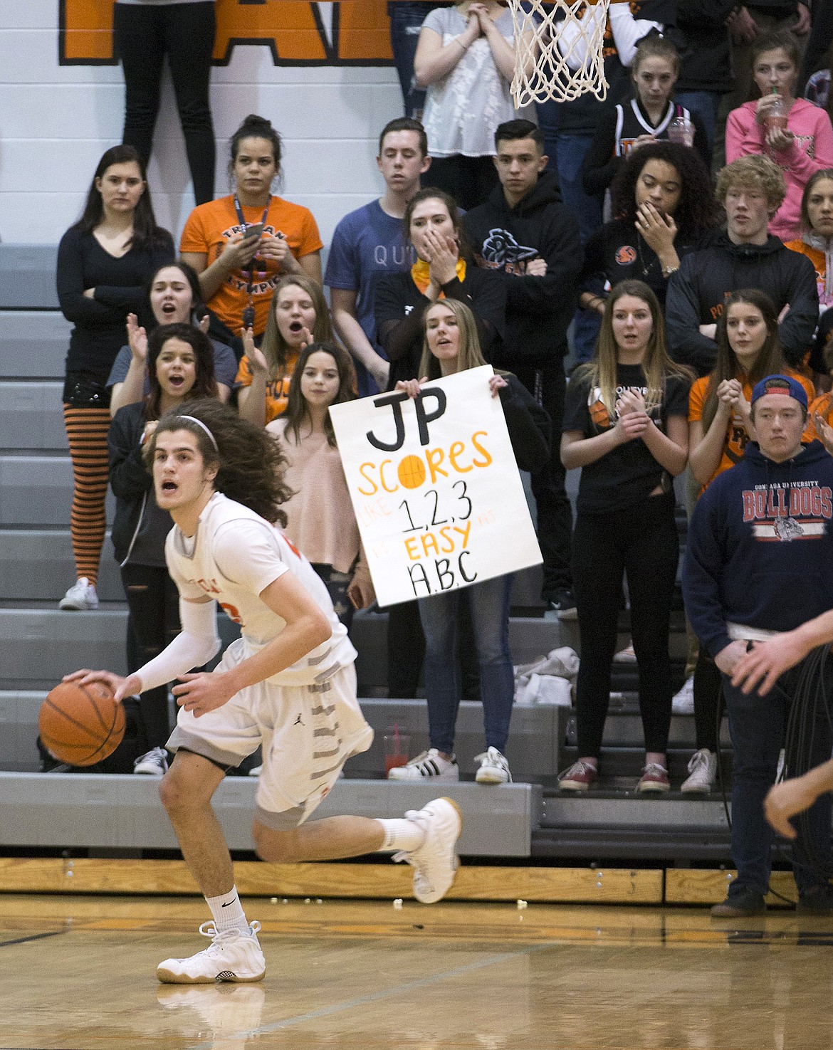 LISA JAMES/ PressPost Falls fans cheer on Jake Pfennigs as he drives down the court during the second half of their State 5A Region 1 championship game at Post Falls High School on Tuesday night. Post Falls lost to Lewiston, 48-51.