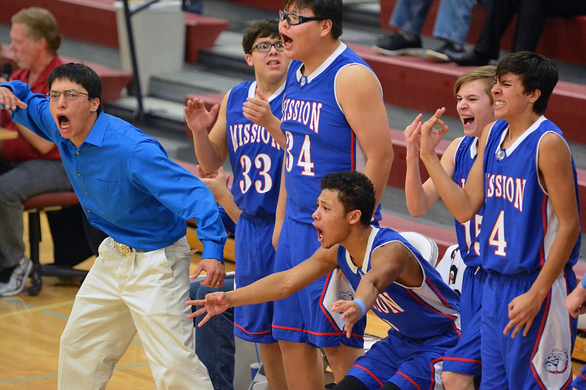 MISSION HIGH School coach Gus McDonald and his Bulldogs team cheer each other on as they took a third quarter lead against Anaconda Thursday night at Hamilton High School. (Photos by Jason Blasco/Lake County Leader)