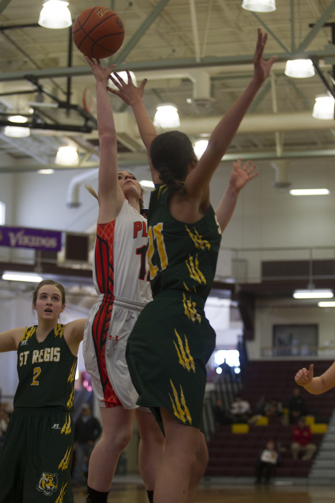 Lindsay Laws (12) of Plains goes up for a shot over St. Regis defender Justice Tate (21). (Jeremy Weber/Clark Fork Valley Press)