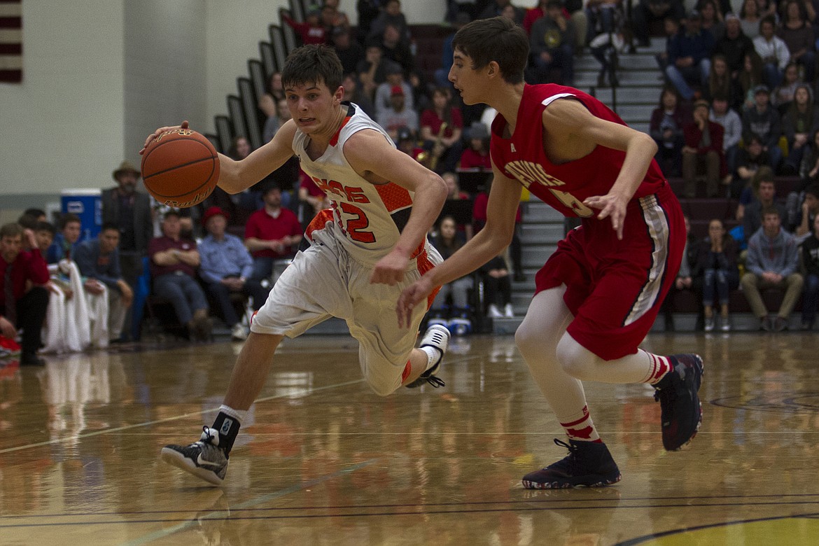 Plains guard Aaren Vonheeder (12) brings the ball up the court against Arlee defender Lane Johnson (5) in the District 14C championship game Saturday. (Jeremy Weber/Clark Fork Valley Press)