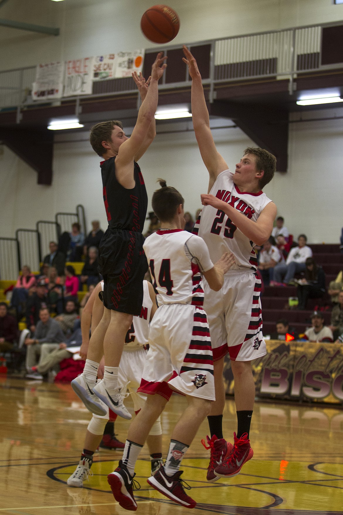 Hot Springs guard Trevor Paro takes a shot over Noxon defenders Quincy Grupenhoff (25) and Cody Cable (14) Thursday. (Jeremy Weber/Clark Fork Valley Press)