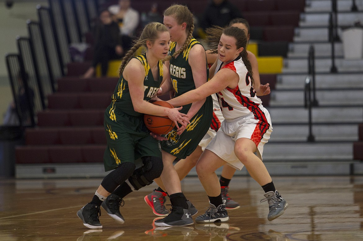 Plains defender Natalle Deschamps (24) attempts to knock the ball away from St. Regis guard Madison Hill during semifinal action in Pablo Friday. (Jeremy Weber/Clark Fork Valley Press)