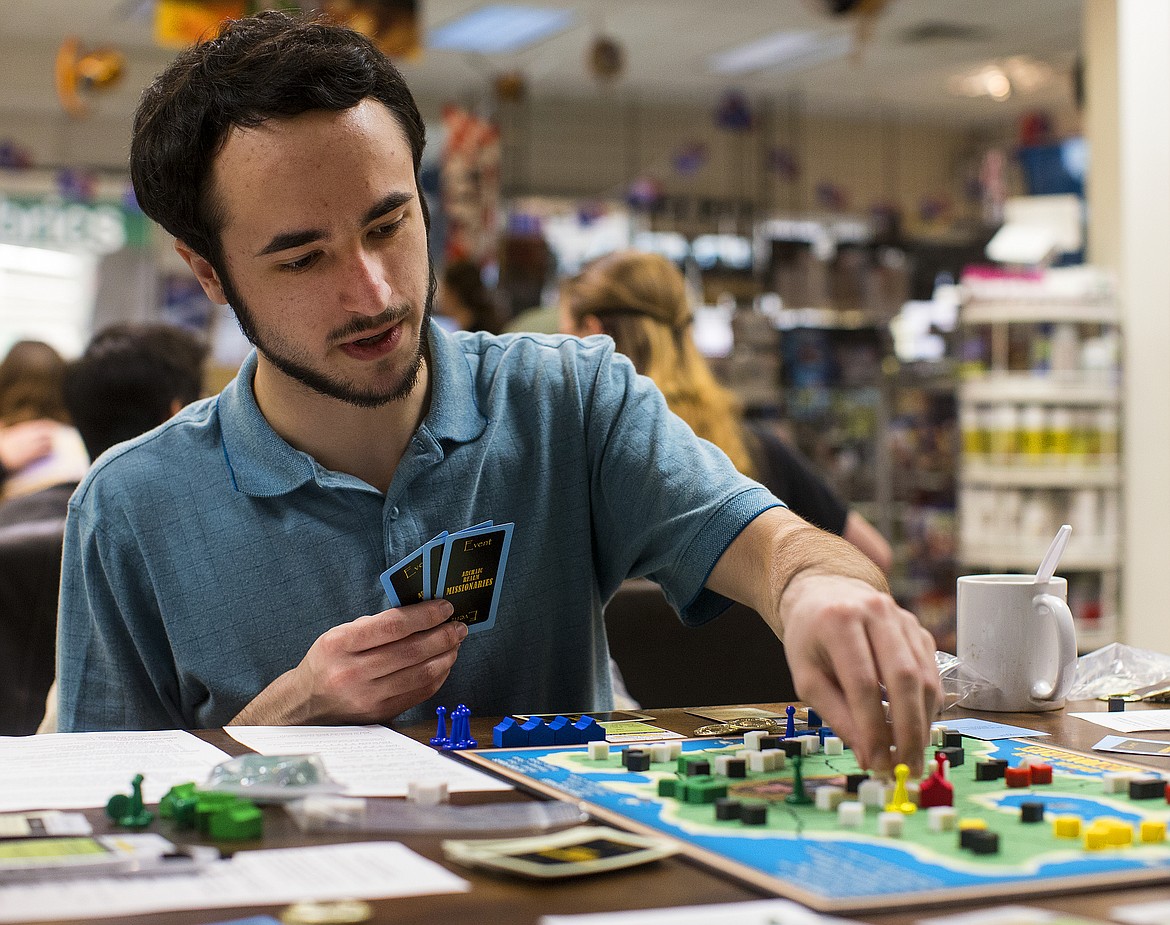 LOREN BENOIT/PressKeaton Marschman places a believer cube on a board during a &quot;Archaic Realm Missionaries&quot; play-test event Monday at Silver Lake Mall.