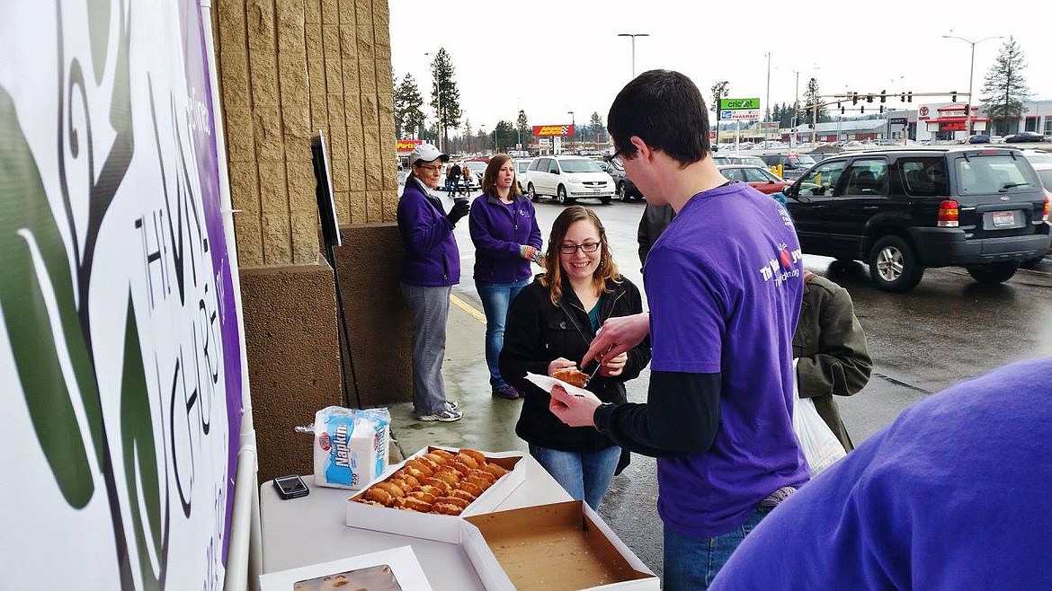 Courtesy photo 
A shopper smiles Saturday at Super 1 Foods in Coeur d&#146;Alene as she accepts a free doughnut from a member of The Vine Church.