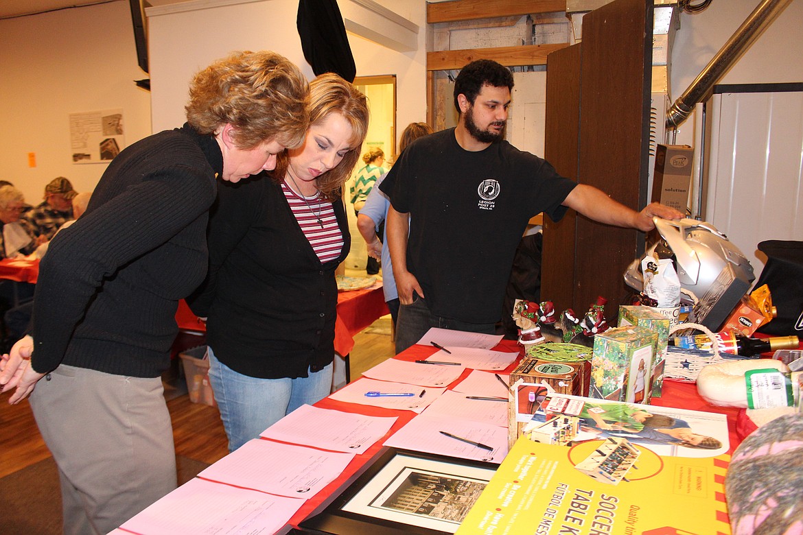 Cheryl Schweizer/Columbia Basin Herald
Attendees at the annual Grant County Animal Outreach fundraising &#145;Spay-ghetti&#146; dinner look over the auction items.