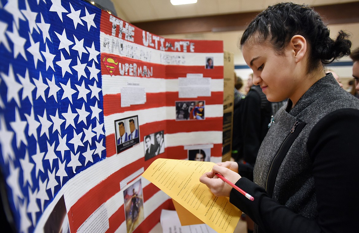 Eighth-grader Tiana Myers takes notes about a project on display for National History Day at the Bigfork elementary and middle school on Tuesday. (Brenda Ahearn/Daily Inter Lake)