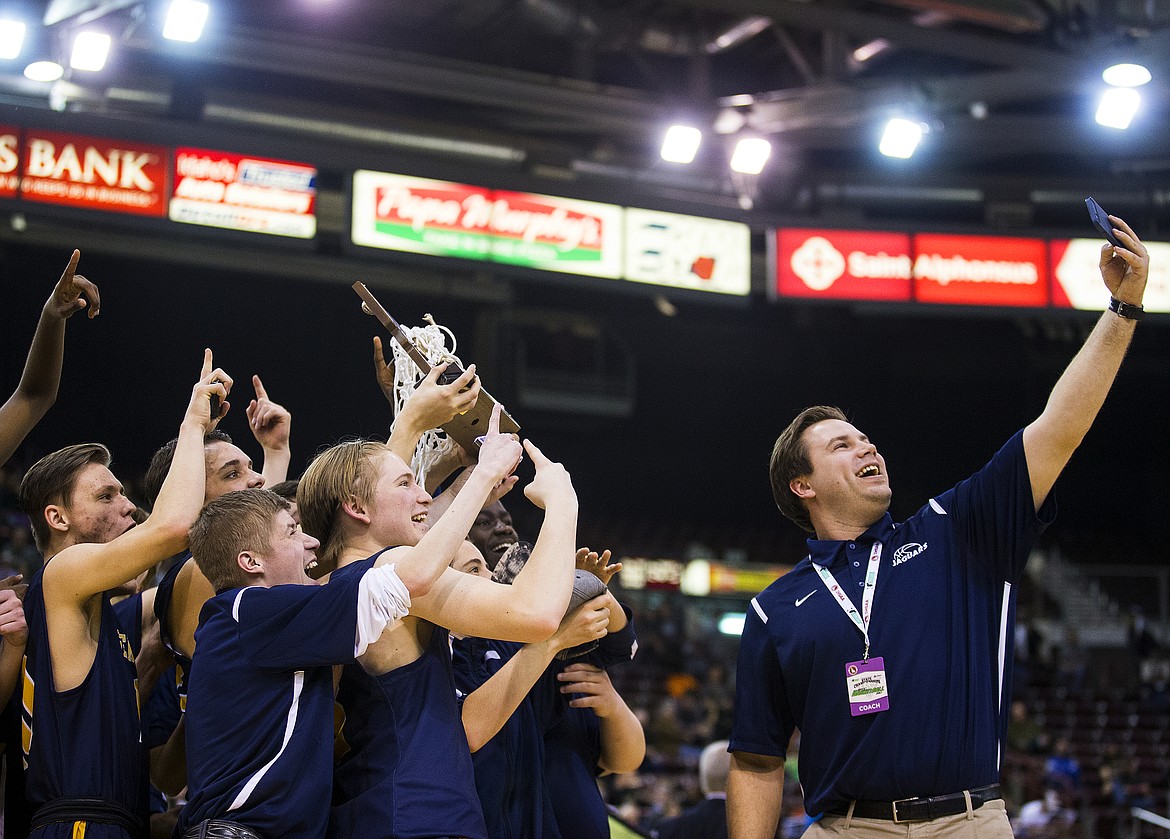 LOREN BENOIT/Press

Genesis Prep assistant coach Brandon Haas takes a selfie with his team and the 1A Division II trophy after defeating Deitrich 68-62 in the 1A Division II championship game at the Ford Idaho Center Saturday morning in Nampa.