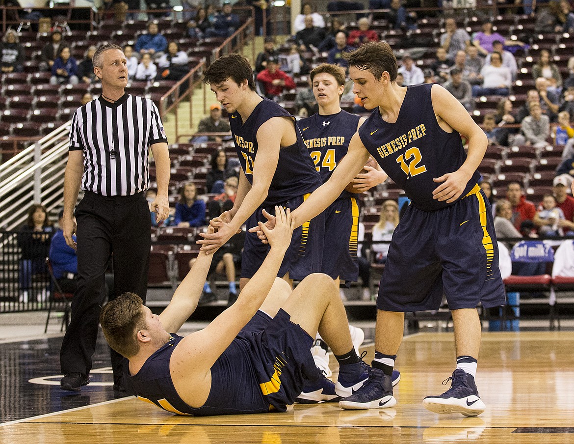 LOREN BENOIT/PressGenesis Prep players Junior Williams (21) and Max Reidt help Luke Gonzales back onto his feet.