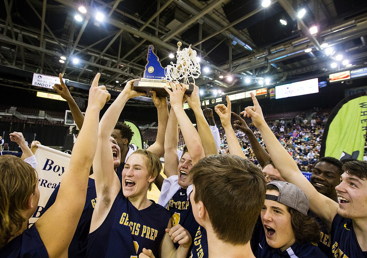 LOREN BENOIT/PressGenesis Prep players hoist their 1A DII championship trophy after defeating Dietrich 68-62 Saturday morning at the Ford Idaho Center.