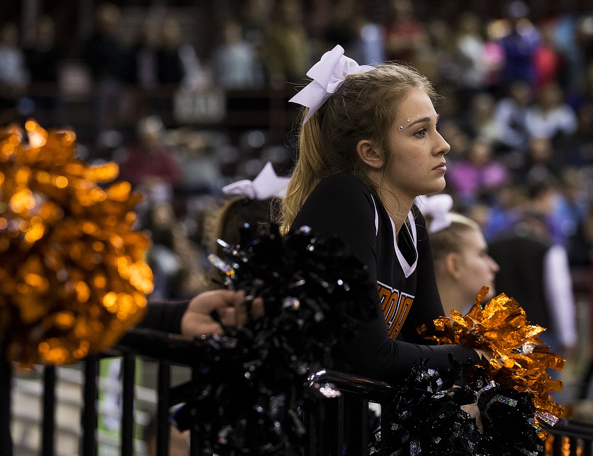 LOREN BENOIT/PressCheerleader Mindie Schmeling watches Centennial High School players celebrate their 72-61 win against Post Falls Friday night o advance to the title game.