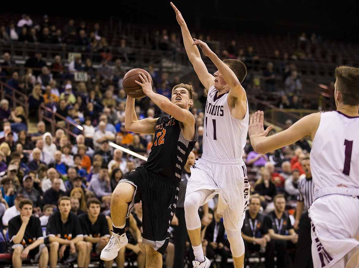 LOREN BENOIT/PressPost Falls' David Dourgard (12) drives to the basket while defended by Centennial's Jackson Cleverley.