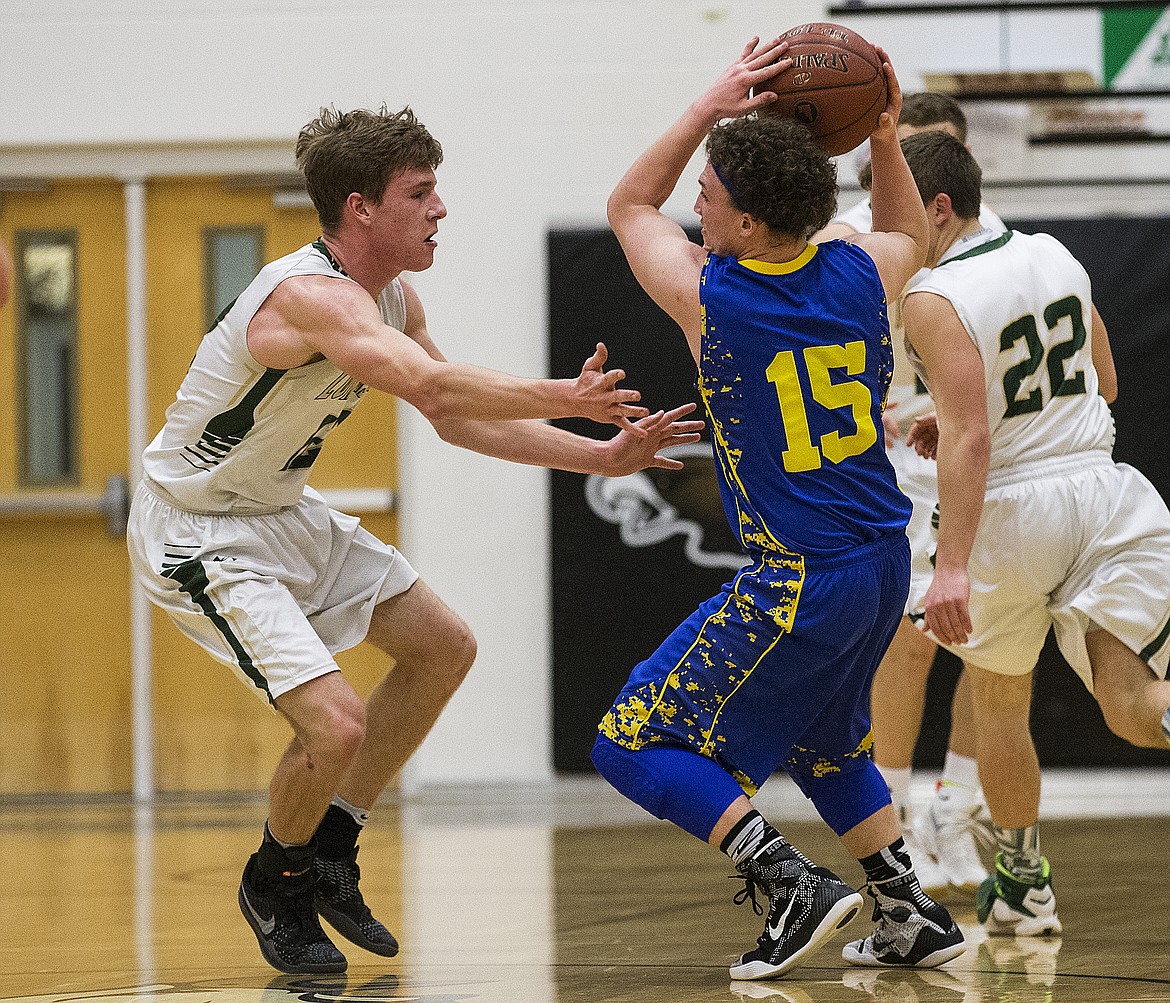 LOREN BENOIT/PressKiefer Gibson (12), left, of St. Maries, applies pressure to during Ririe's Jace Johnson Friday's 5A state semifinal game at Capital High School.