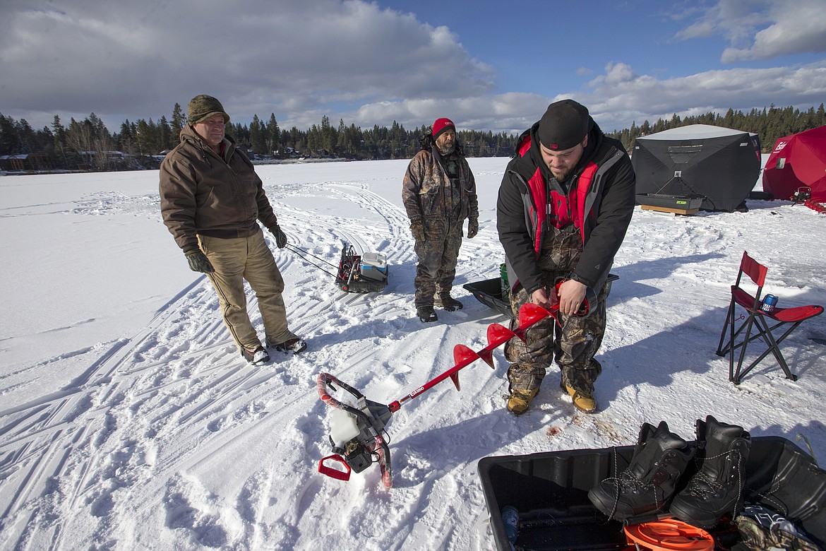 Ice fishermen start packing up their auger and other things around their encampment after a full day of fishing Tuesday on Hayden Lake.