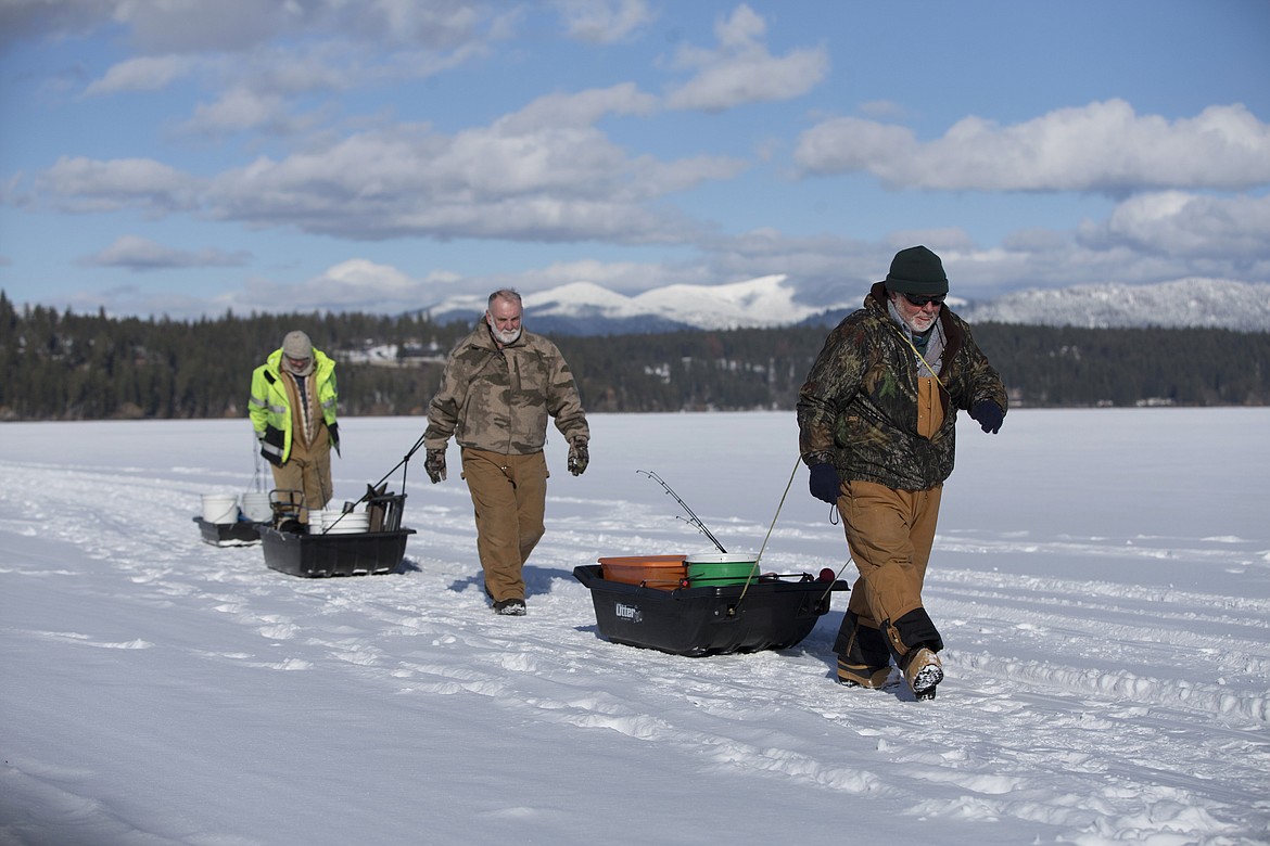 Dan Johnson, front, Eldon Hall, center, and Don Johnson head out with the day&#146;s catch after ice fishing.