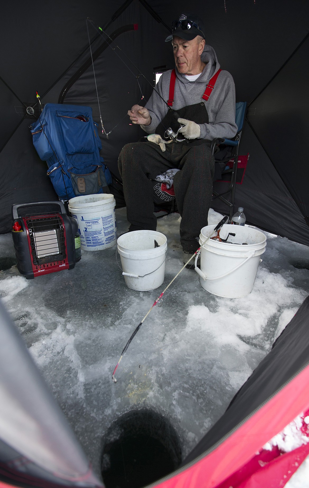 Chuck Moreland, of Coeur d&#146;Alene, puts bait on his hook as he fishes from his ice fishing tent.