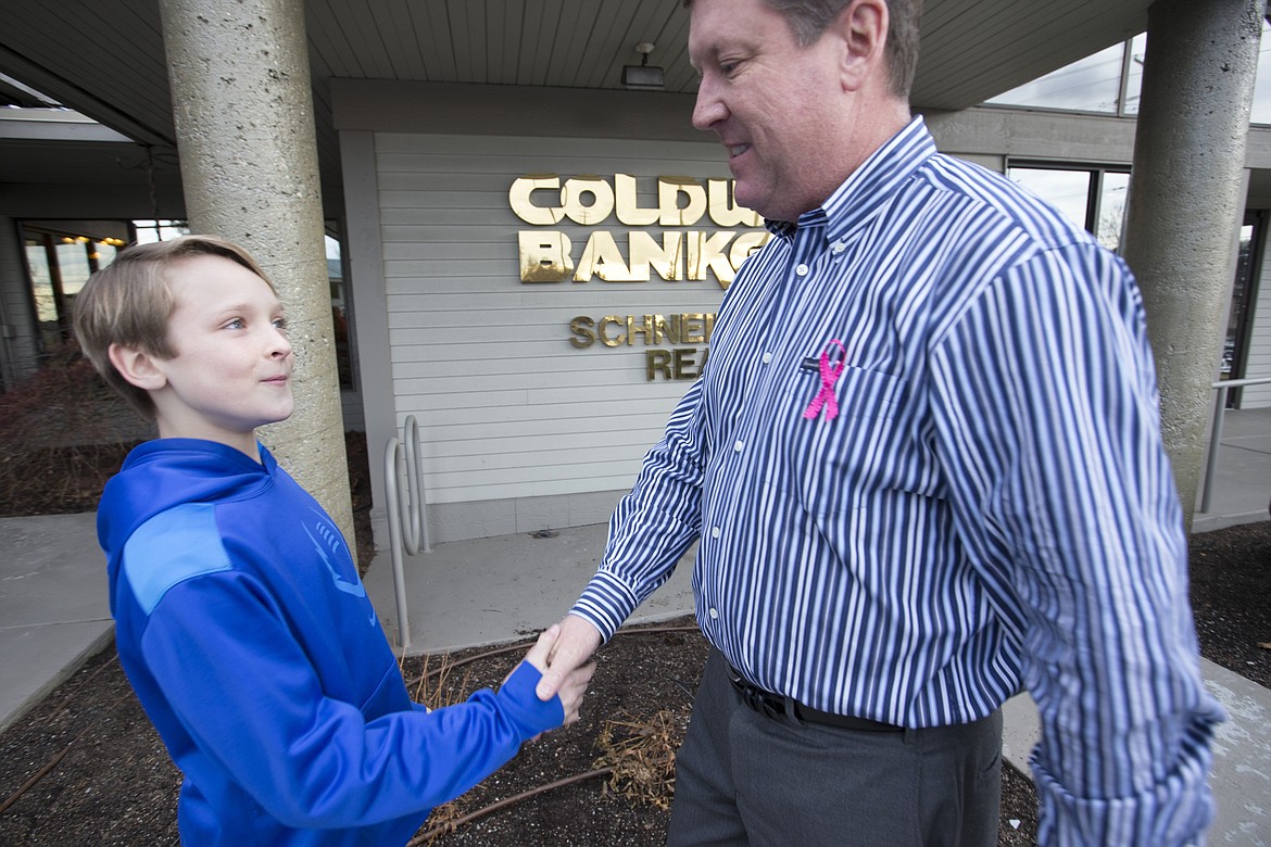 LISA JAMES/PressFernan 6th grader Kyle Bridge, 12, thanks Coldwell Banker President Mark Johnson on Wednesday for the donation which will help the school build a playground to accommodate their special needs students.Caldwell Banker of Coeur d'Alene donated $5,000 to Fernan Elemantary School to help build a playground which will be accessible to special needs students. The project was researched by Kyle and a team of three of his other classmates.