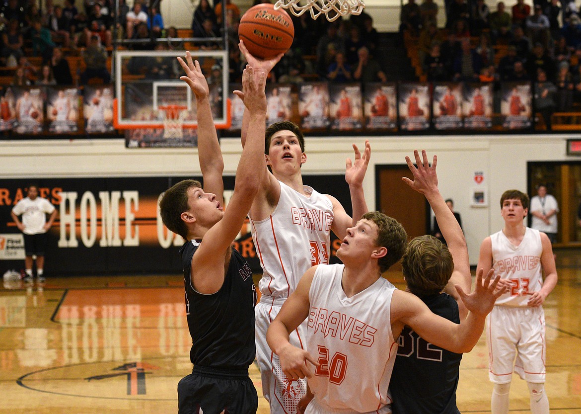 Flathead post Sam Elliott floats up a shot in the key against Helena at Flathead on Thursday. Elliott led the Braves with 20 points. (Aaric Bryan/Daily Inter Lake)