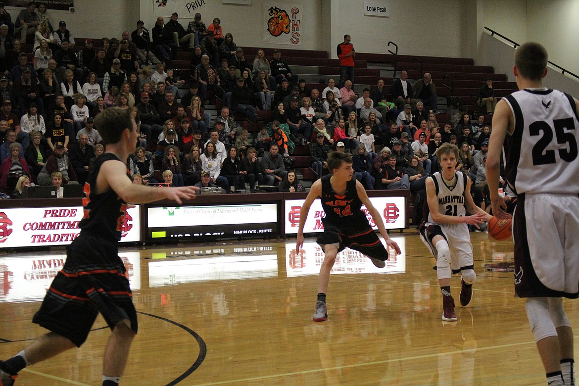 Plains Horseman (#14 in black) Kyle weeks is on the defensive as a Manhattan Christian player moves around him.