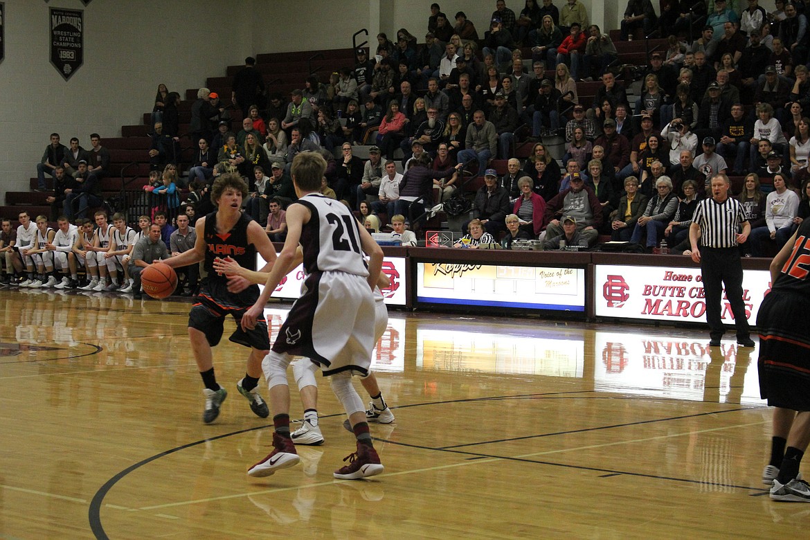 Ryan Ovitt starts to move past the two Manhattan Christian players.