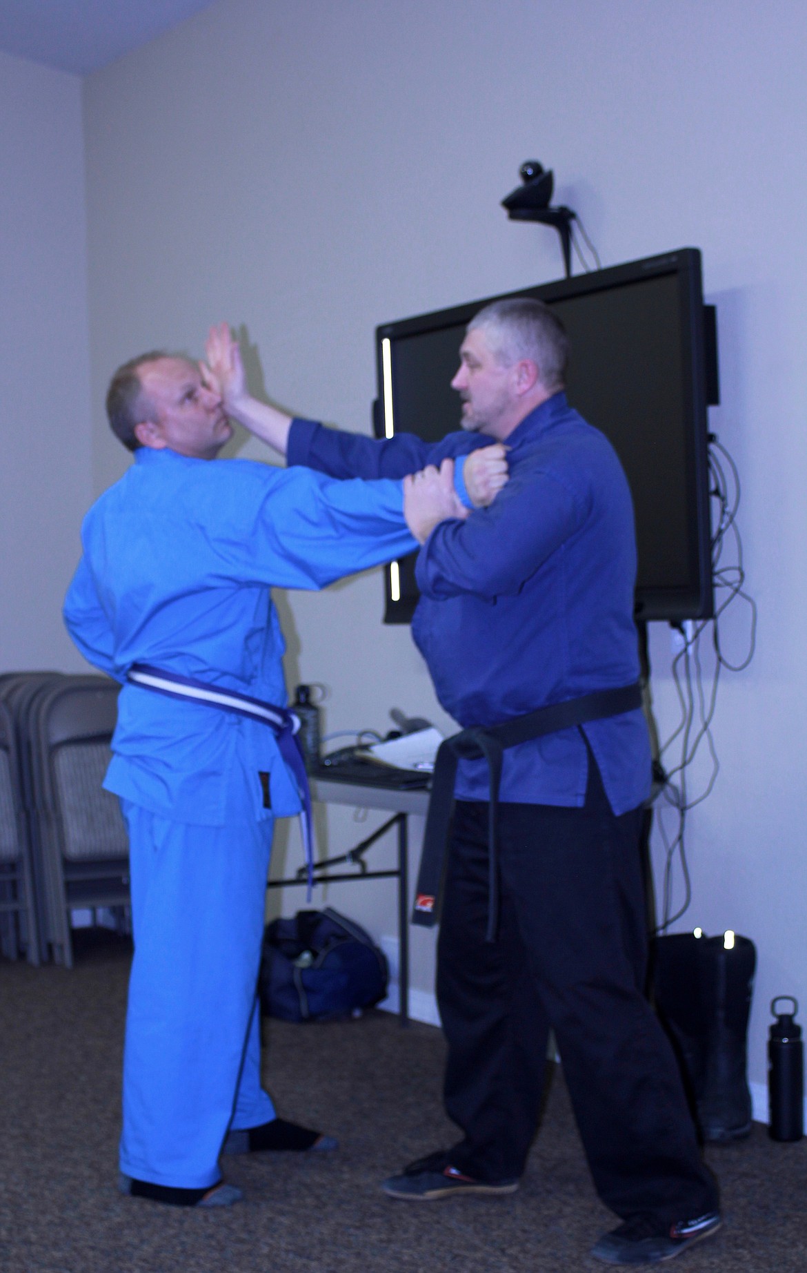 CHRIS LYMAN (left) grabs the collar of Blue Heron Karate Academy sensei Jason Williams, who demonstrates a grab and block move to students. (Douglas Wilks photos/Clark Fork Valley Press)