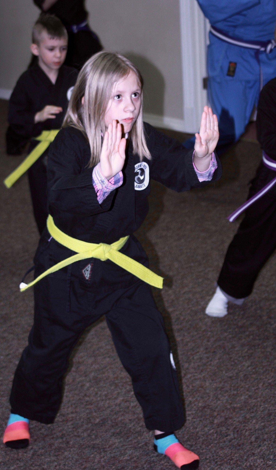 JASMINE TRULL, 9, practices her passive guard stance during a family class at Blue Heron academy.