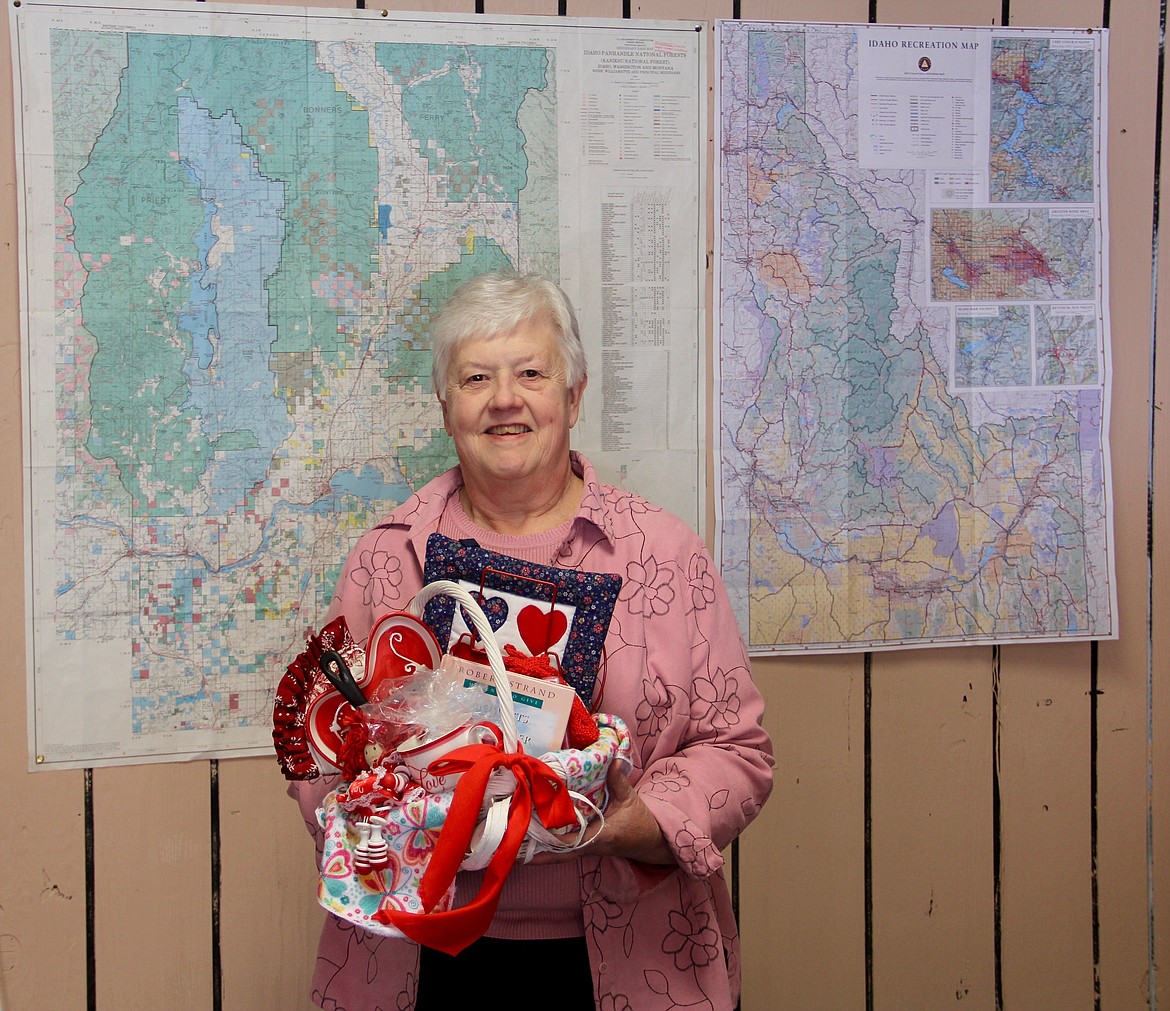 &#151;Photo by DAC COLLINS
Linda Ault, who worked at the Boundary County auto license office before retiring, holds up the kitchen-themed basket that she won in this year's Friends of the Restorium's Valentine's Day Raffle.