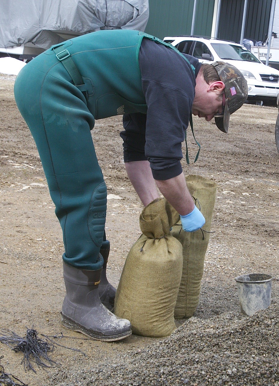 BRIAN WALKER/Press
Ben Mathey fills sandbags at a pile on Search Light Lane off of Wolf Lodge Creek Road on Thursday.