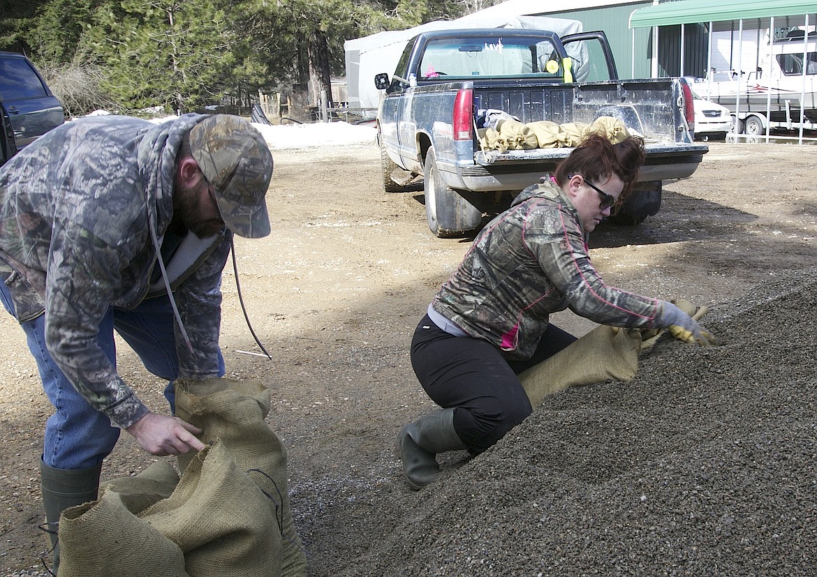 BRIAN WALKER/Press
Patrick and Janette Byrne fill sandbags before taking them to their property off of Wolf Lodge Creek Road on Thursday.