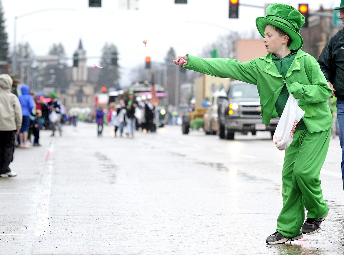 Michael Manning tosses candy to the crowd during the St. Patrick&#146;s Day parade in downtown Kalispell on Tuesday. (Aaric Bryan/Daily Inter Lake)