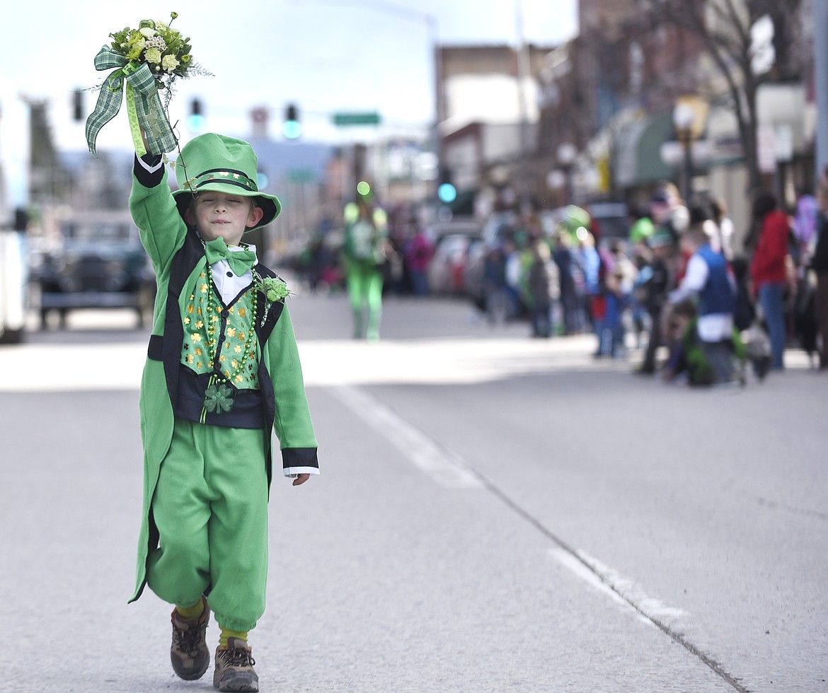 Max Young holds up flowers as he walks with the Rose Mountain Floral participants in a previous St. Patrick&#146;s Day Parade in Kalispell. (Aaric Bryan/This Week in the Flathead file photo)